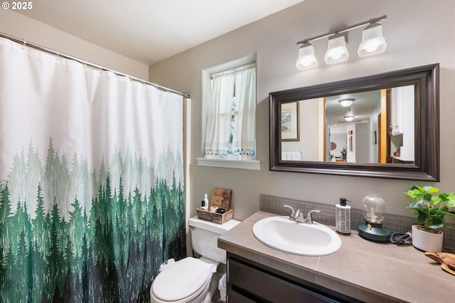 full bath featuring toilet, vanity, and curtained shower