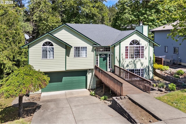 view of front of house featuring concrete driveway, a chimney, roof with shingles, and an attached garage