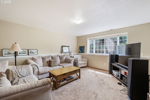 living area with baseboards, light carpet, visible vents, and a textured ceiling