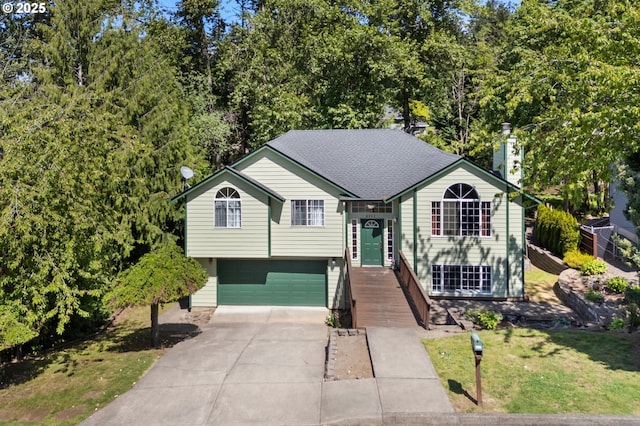 view of front of house with an attached garage, driveway, a chimney, and a front yard