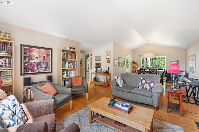 living area with lofted ceiling and wood finished floors