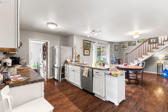 1495 N Hemlock St, Coquille, OR 97423 - kitchen featuring appliances with stainless steel finishes, a peninsula, dark wood finished floors, and white cabinetry