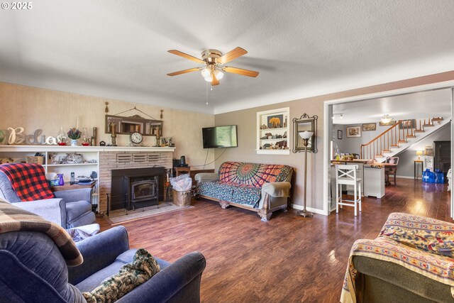 1495 N Hemlock St, Coquille, OR 97423 - living room featuring a ceiling fan, stairs, wood finished floors, a wood stove, and a textured ceiling