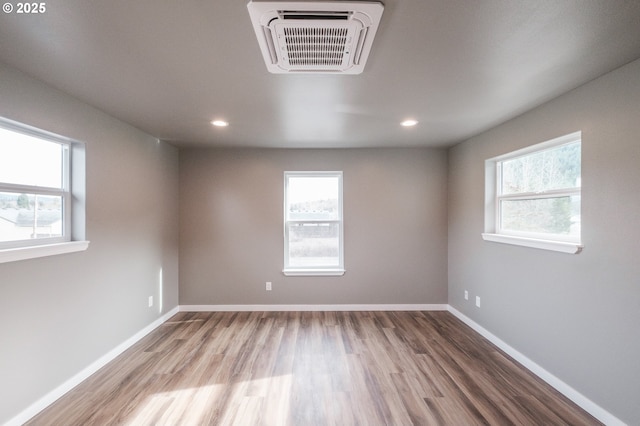 empty room with hardwood / wood-style flooring and a healthy amount of sunlight