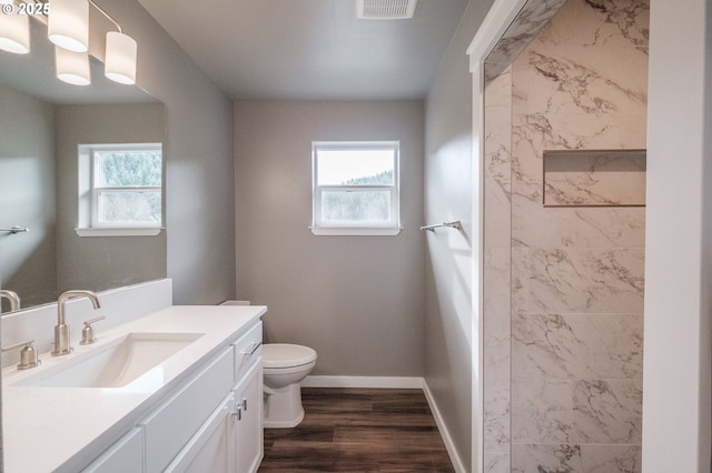 bathroom with vanity, hardwood / wood-style floors, plenty of natural light, and toilet