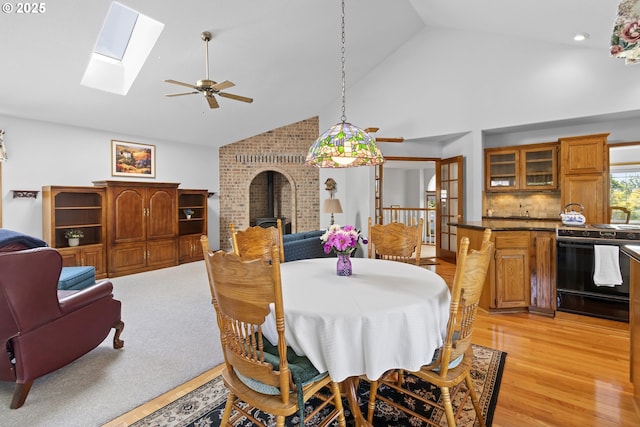 8346 SE 141st Ave, Portland, OR 97236 - dining room featuring a skylight, light wood-style flooring, high vaulted ceiling, and ceiling fan