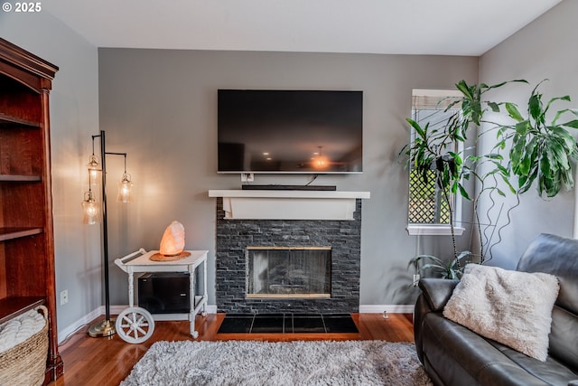 living room with wood finished floors, a fireplace, and baseboards
