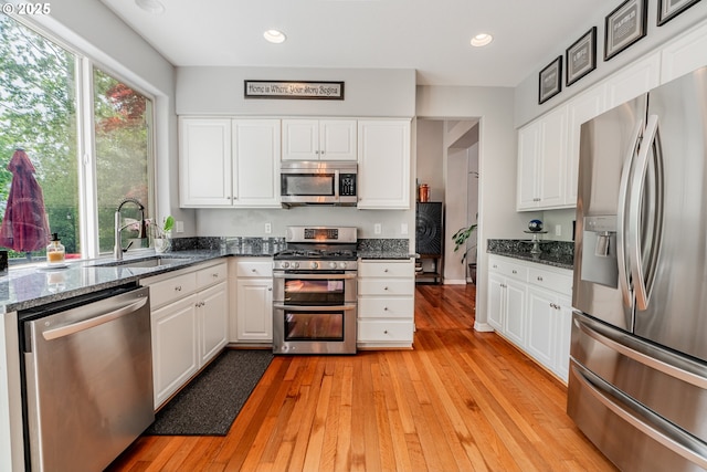 kitchen with appliances with stainless steel finishes, a sink, white cabinetry, and recessed lighting