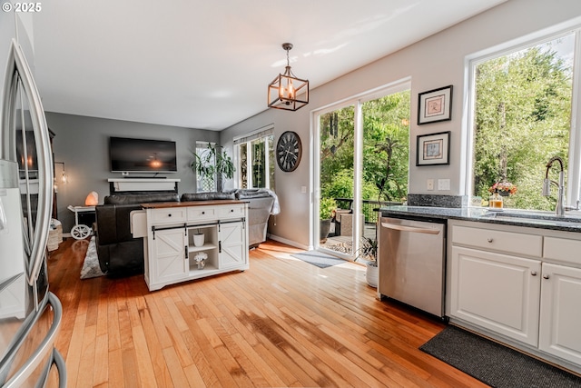 kitchen featuring a sink, stainless steel appliances, white cabinetry, and light wood finished floors