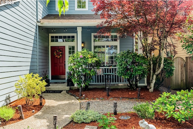 property entrance featuring a porch and fence