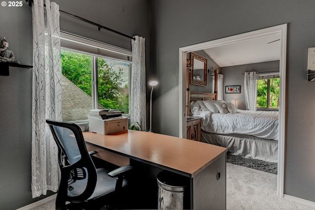 carpeted bedroom with an office area, baseboards, and lofted ceiling