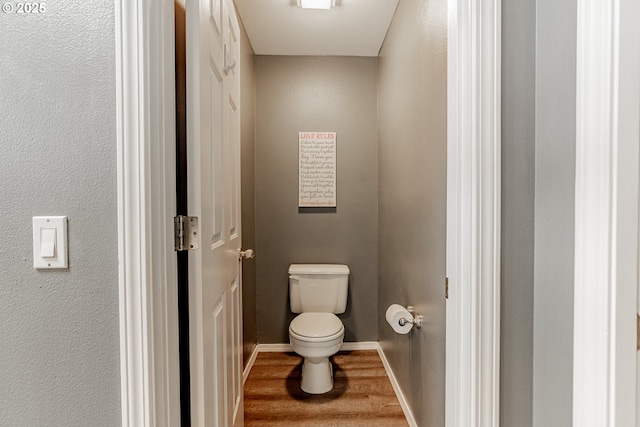 bathroom with wood finished floors, toilet, and baseboards