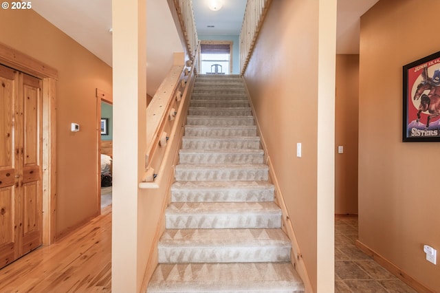 stairs featuring wood finished floors and baseboards