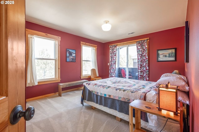 bedroom featuring visible vents, baseboards, and light carpet