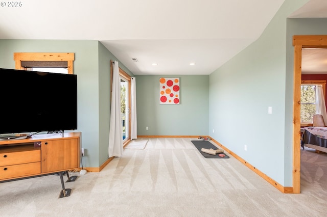 living area with baseboards, recessed lighting, and light carpet