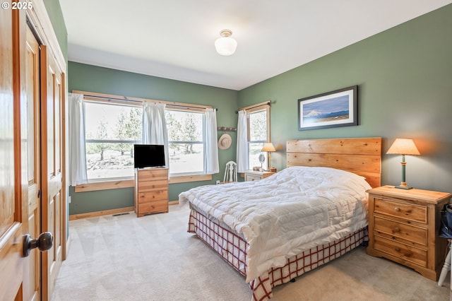 bedroom featuring light carpet and baseboards