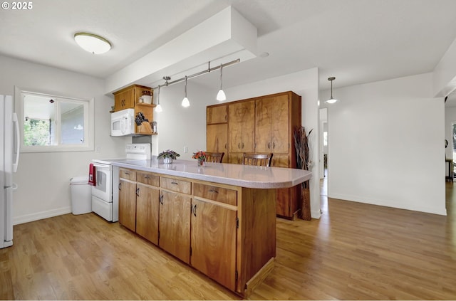 kitchen with white appliances, a peninsula, open shelves, light countertops, and light wood-style floors