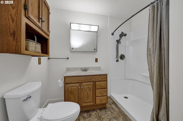 bathroom featuring a shower stall, toilet, and vanity