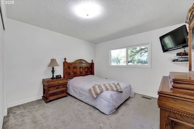 carpeted bedroom featuring baseboards and a textured ceiling