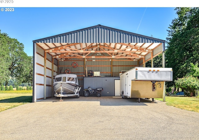 view of outdoor structure with a detached carport and asphalt driveway