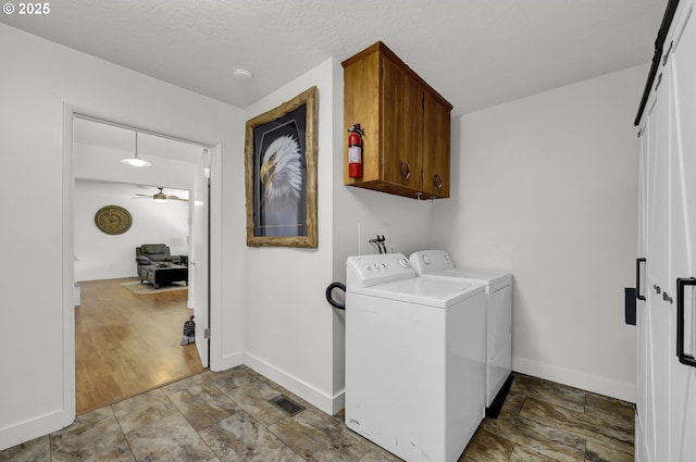 laundry area featuring cabinet space, separate washer and dryer, baseboards, a ceiling fan, and stone finish floors