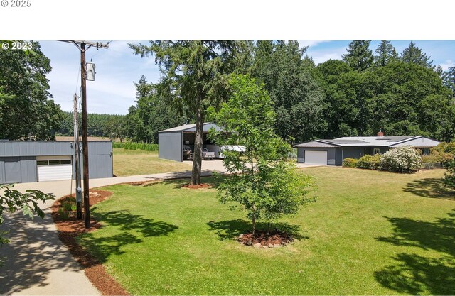 view of green lawn featuring an outbuilding and a garage