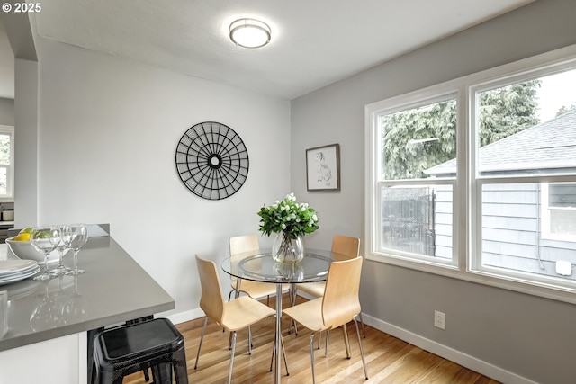 dining area with light wood-style floors and baseboards