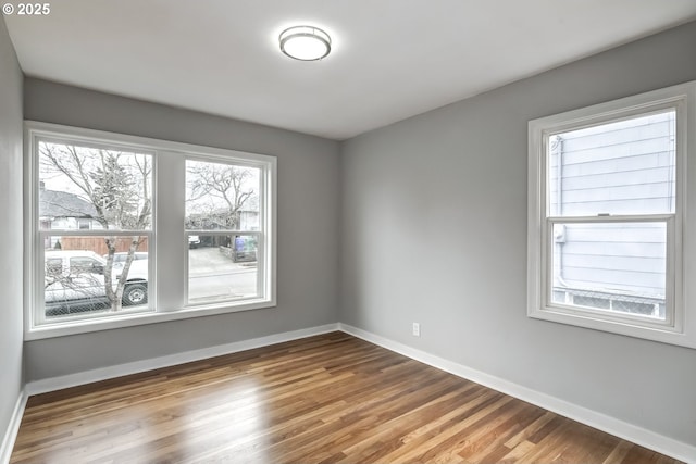 unfurnished room featuring baseboards and wood finished floors