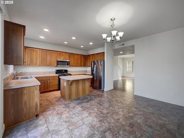 kitchen with visible vents, a sink, a center island, stainless steel appliances, and baseboards