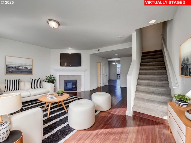 living area with stairway, visible vents, wood finished floors, and a fireplace