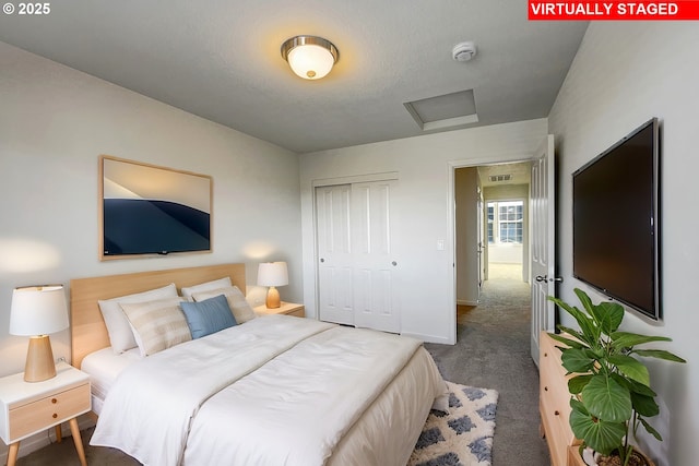 bedroom featuring visible vents, attic access, a closet, and carpet flooring