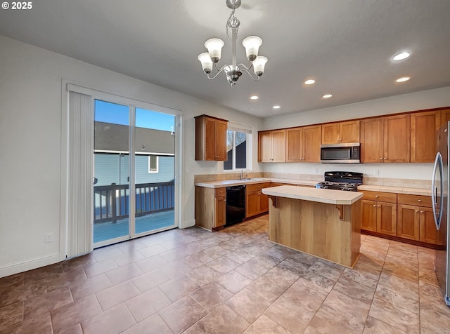 kitchen with a center island, appliances with stainless steel finishes, brown cabinetry, tile counters, and a chandelier