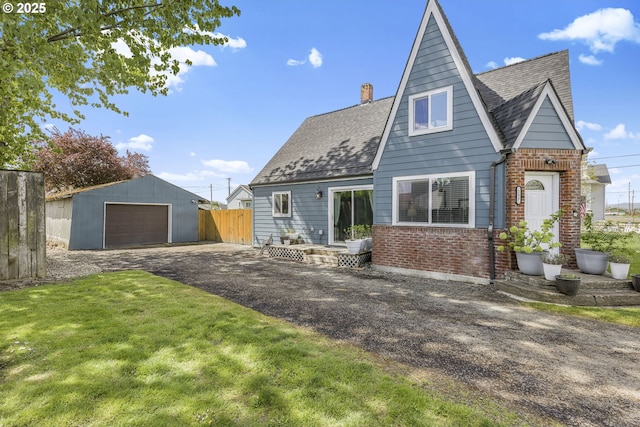 255 W F St, Halsey, OR 97348 - rear view of house featuring brick siding, an outbuilding, a chimney, a detached garage, and a shingled roof