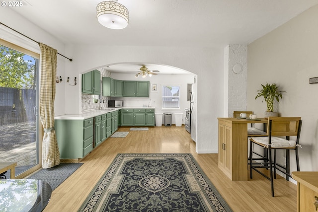 255 W F St, Halsey, OR 97348 - kitchen featuring green cabinets, a sink, ceiling fan, arched walkways, and light wood-style floors