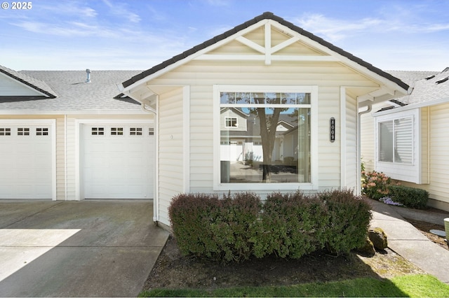 view of front of home with an attached garage, a shingled roof, and concrete driveway
