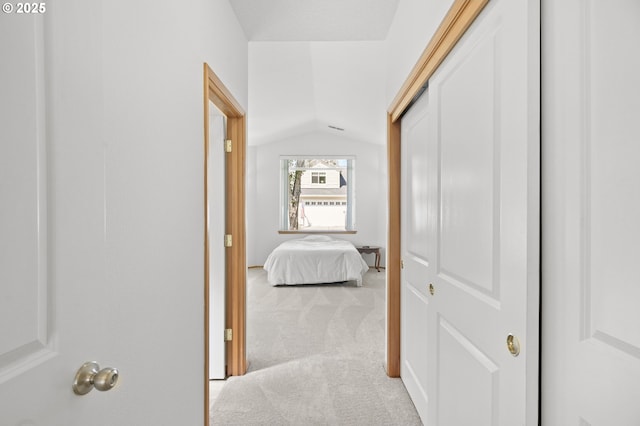 hall featuring carpet and vaulted ceiling