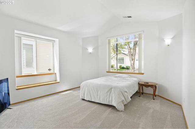 carpeted bedroom featuring baseboards, lofted ceiling, and visible vents
