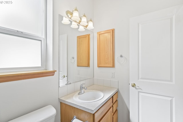 half bathroom with vanity and toilet