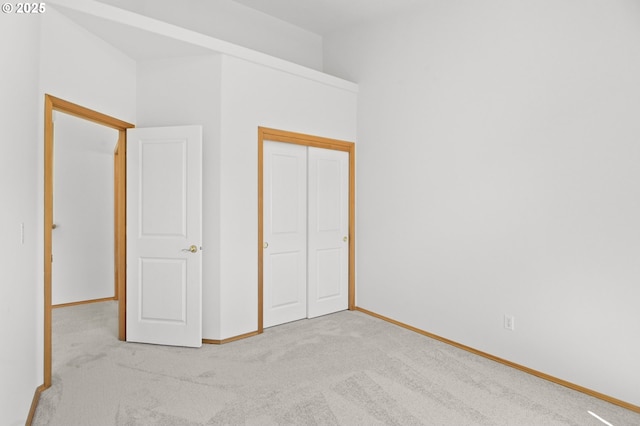 unfurnished bedroom featuring carpet floors, baseboards, and a closet