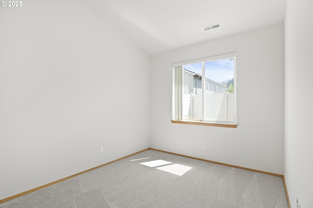 unfurnished room with carpet floors, baseboards, visible vents, and vaulted ceiling