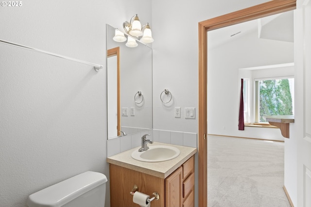 bathroom with toilet, lofted ceiling, and vanity