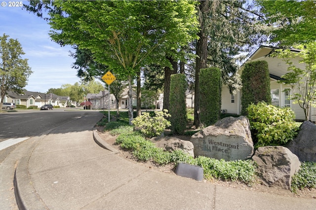 exterior space featuring traffic signs, sidewalks, and a residential view
