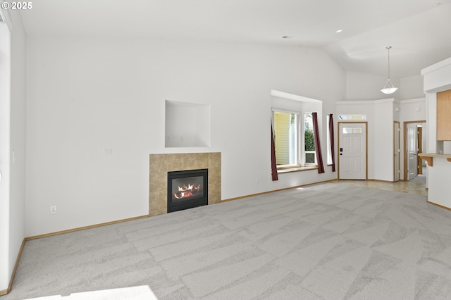 unfurnished living room with baseboards, light carpet, high vaulted ceiling, and a tile fireplace