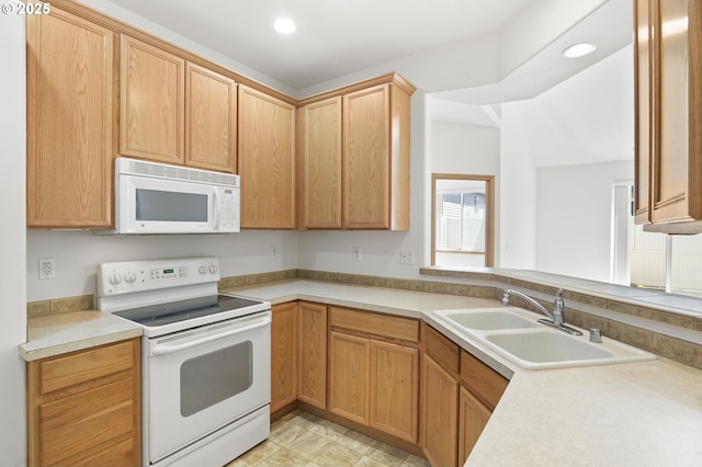 kitchen featuring recessed lighting, a sink, white appliances, and light countertops
