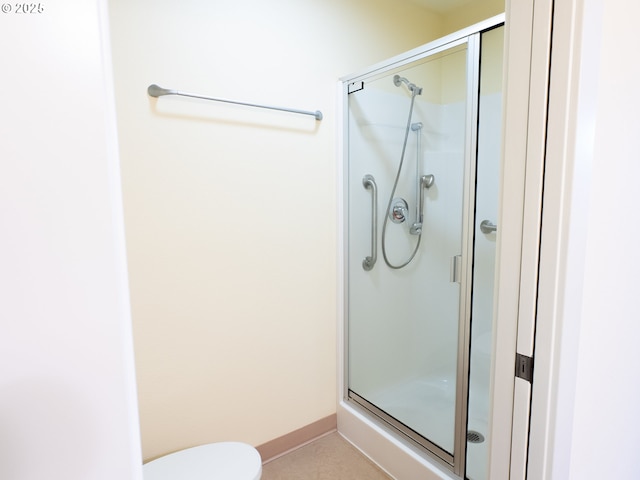 bathroom with toilet and an enclosed shower