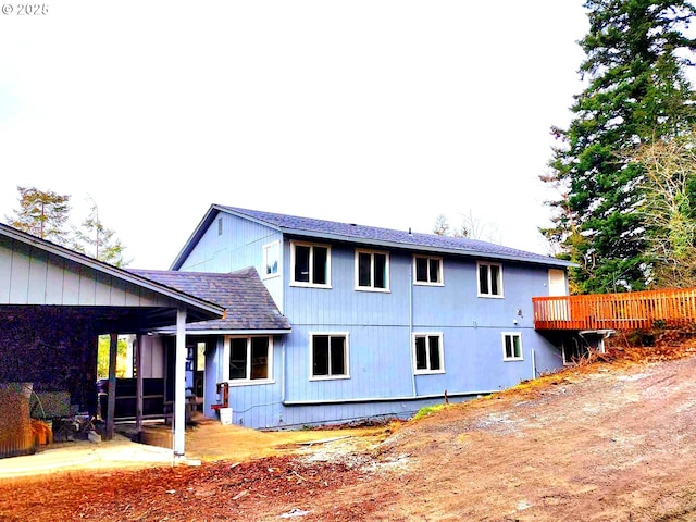back of house featuring a shingled roof and a patio area