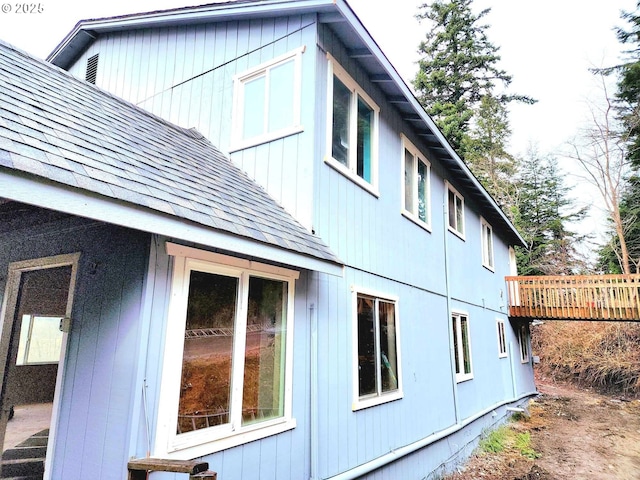 view of side of home featuring roof with shingles