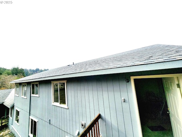 view of side of home with a shingled roof