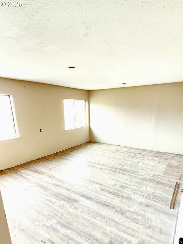 unfurnished room featuring a textured ceiling and wood finished floors