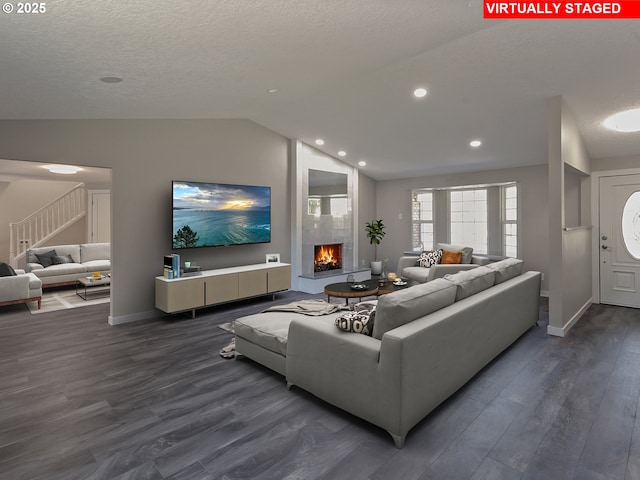 907 NW 90th St, Vancouver, WA 98665 - living room with vaulted ceiling, dark wood-style floors, a textured ceiling, a large fireplace, and stairs